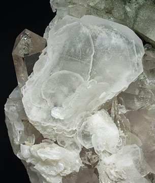 Calcite (variety papierspat) with Quartz (variety smoky quartz) and Chlorite. 