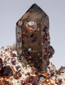 Spessartine with Quartz (variety smoky) and Feldspar. 